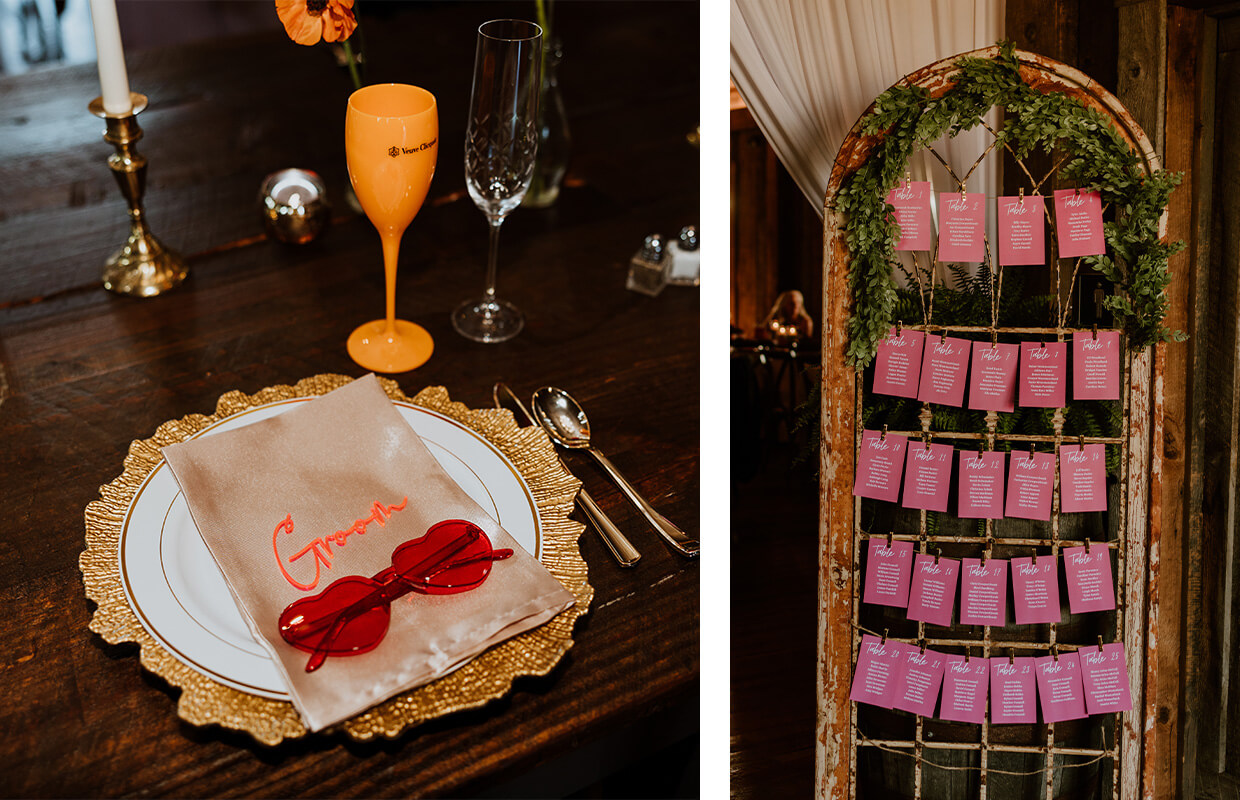 A table setting with a gold-trimmed plate, napkin, and red sunglasses labeled "Groom"; adjacent is a seating chart on a rustic frame with pink cards.
